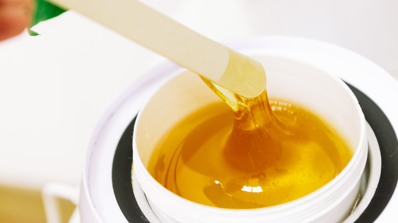 esthetician applying wax on woman's bikini area