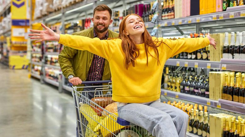 A woman riding shopping cart