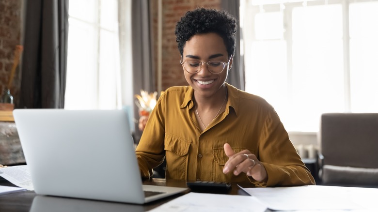 woman creating budget on laptop