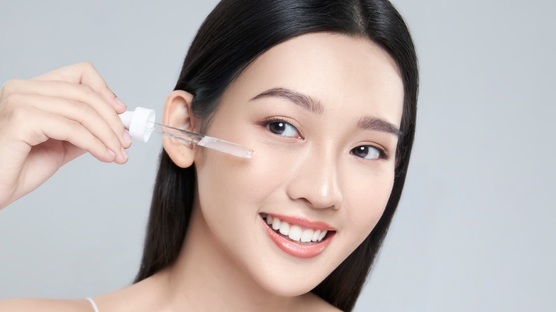 A woman applying serum 