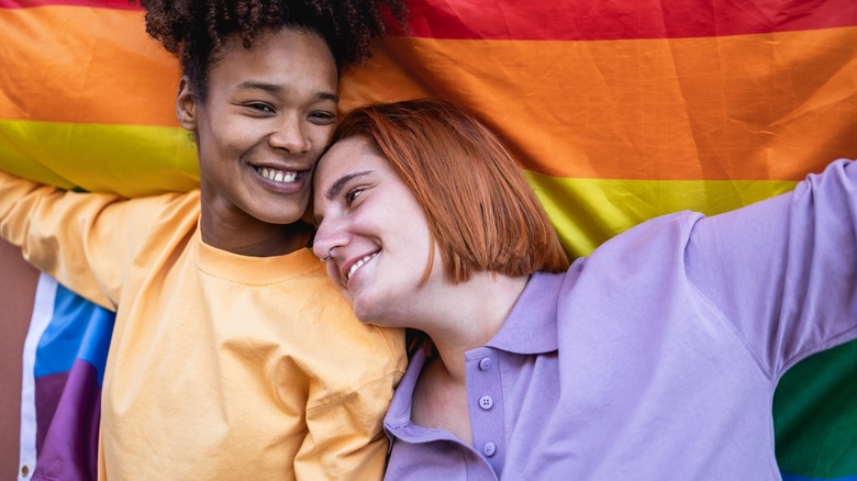 couple smile with pride flag