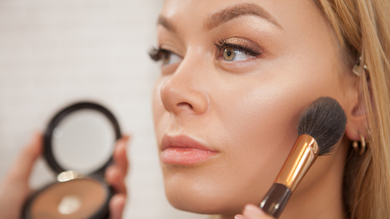 woman getting highlighter applied