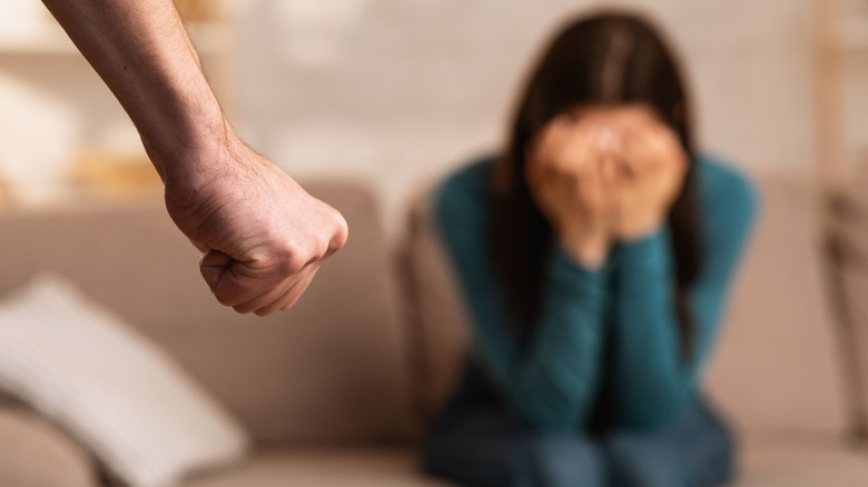 A fist and woman crying