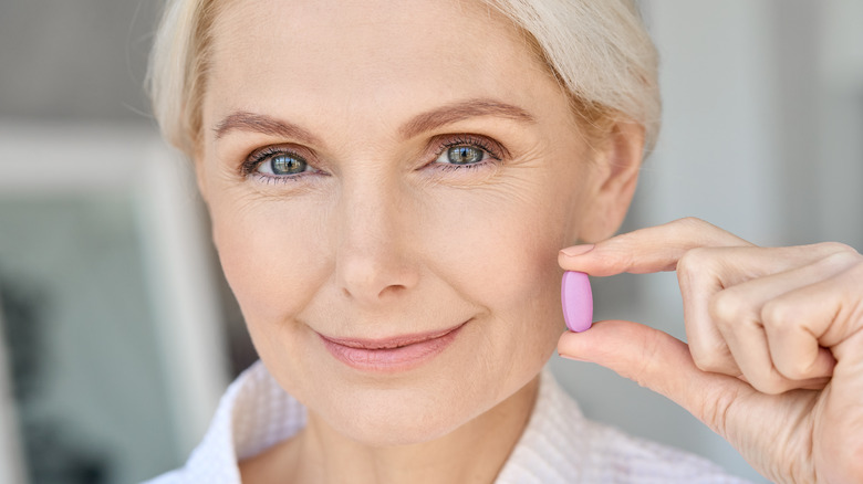 Woman holding collagen supplement 
