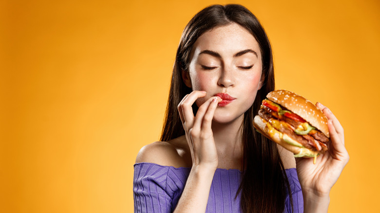 Woman eating cheeseburger