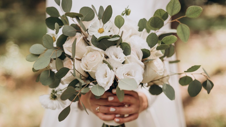 Bride holding white, green bouquet
