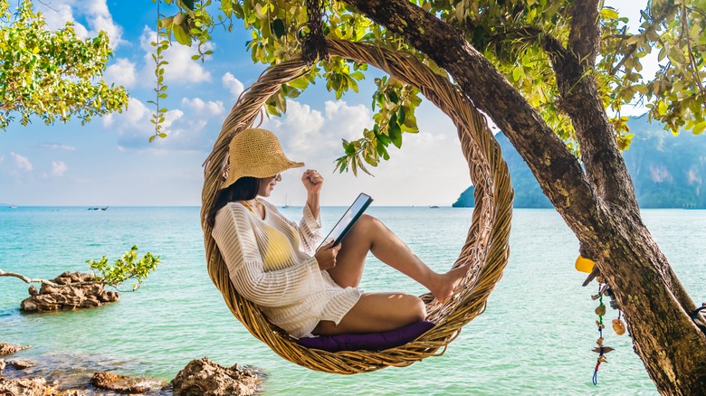 Woman reading in straw hammock