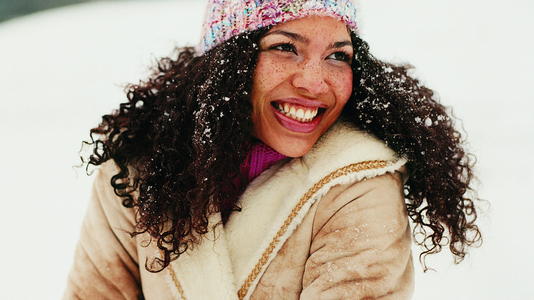 Girl with snow in her hair in winter setting.