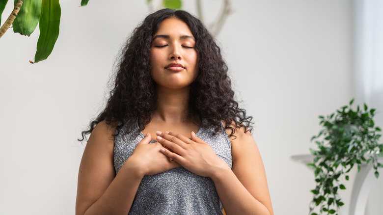 woman breathing with hands on heart