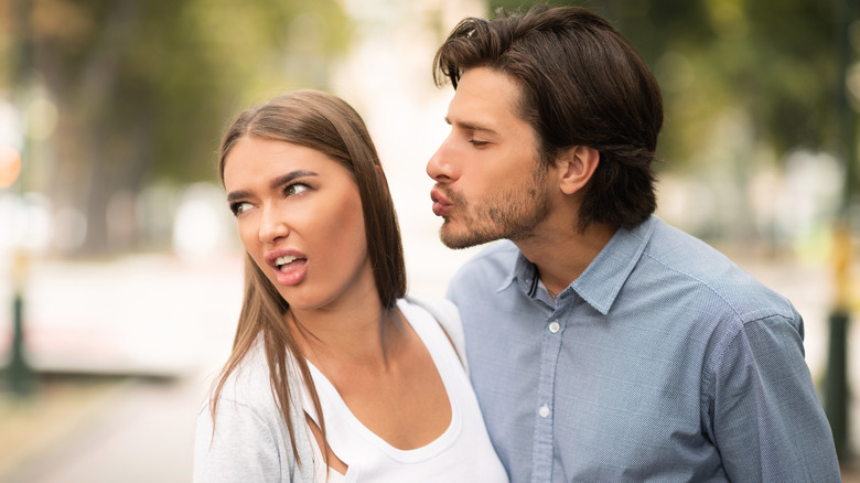 man trying to kiss woman