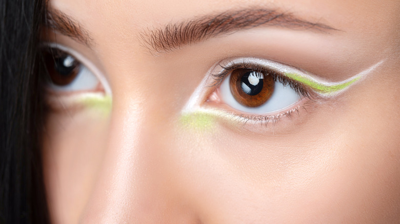 Closeup of white and lime green winged eyeliner 