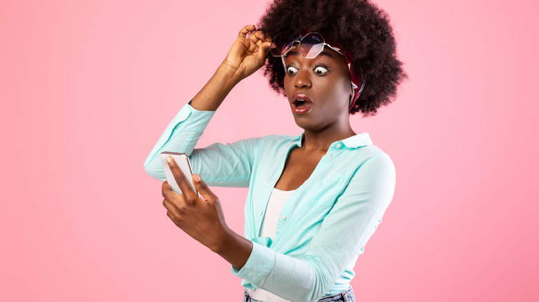 woman shocked reading phone