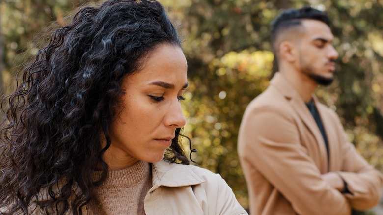 Unhappy couple standing apart outside