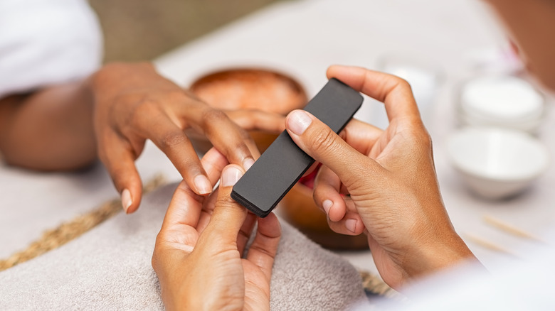 woman getting her nails filed