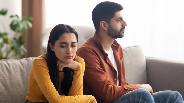 upset couple sitting on couch