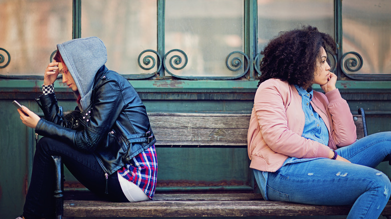 Friends sitting away from each other