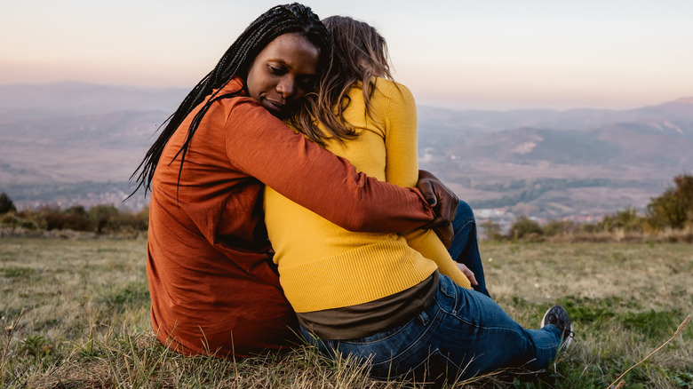 Sad woman is hugged by friend