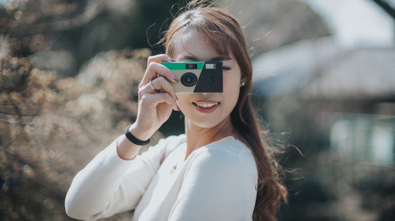 young woman with disposable camera