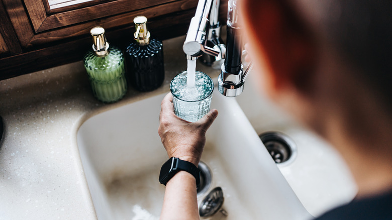 Person fills cup from faucet