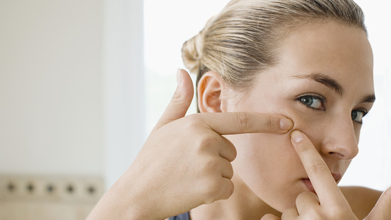 woman popping acne