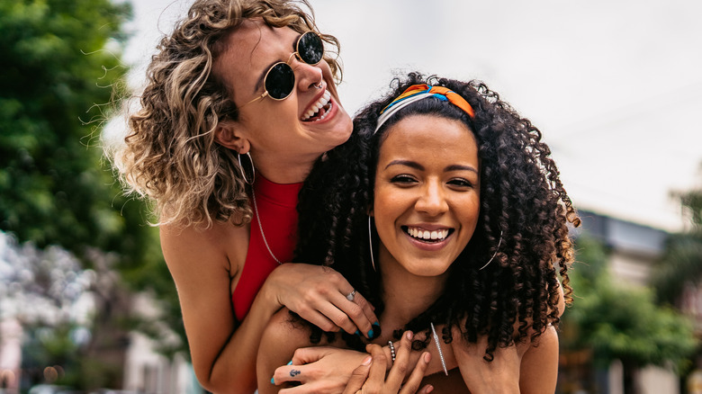 Smiling women hugging in street