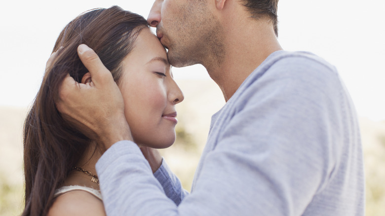 man kissing woman