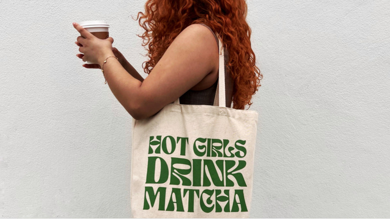 woman carrying coffee and tote bag