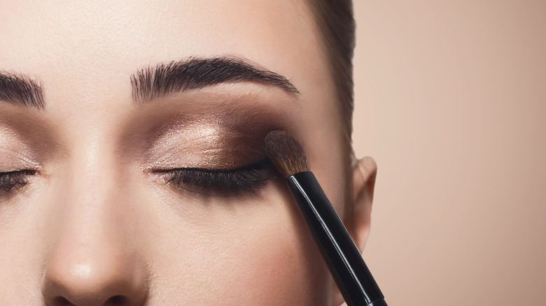 person putting on thick eyeliner