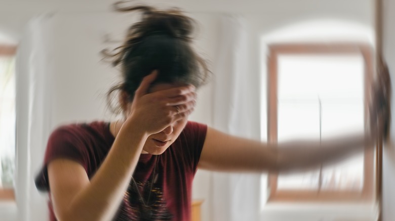 woman holding head in pain