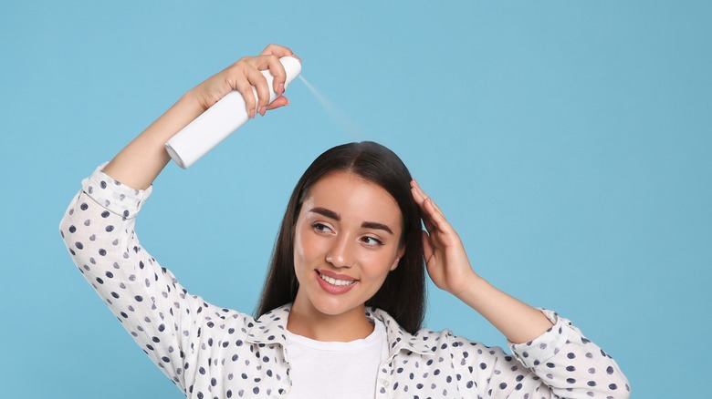 woman applying dry shampoo