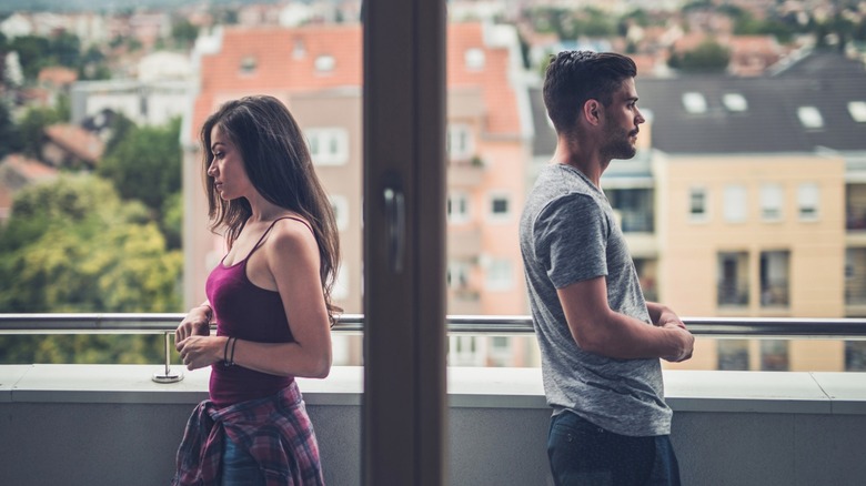 Couple standing back to back