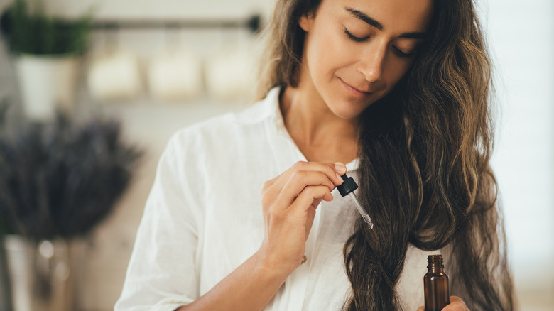 Woman applying hair oil 