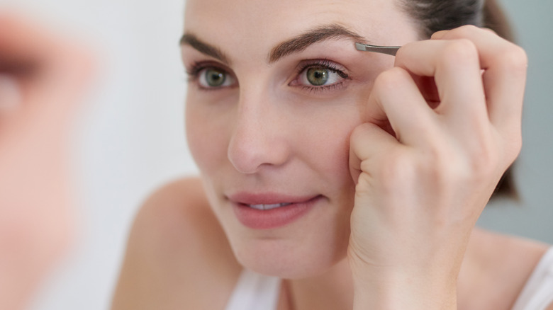 person plucking eyebrow