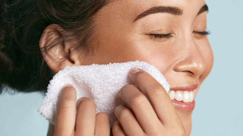 woman washing face with a towel