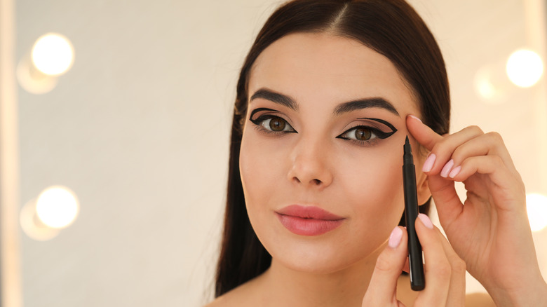 woman applying eyeliner