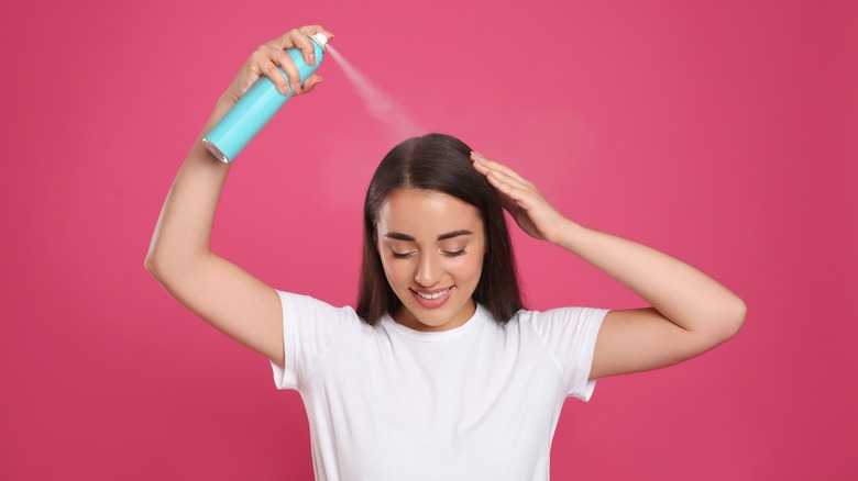 woman applying dry shampoo