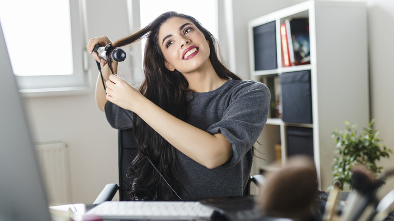 woman curling her hair 