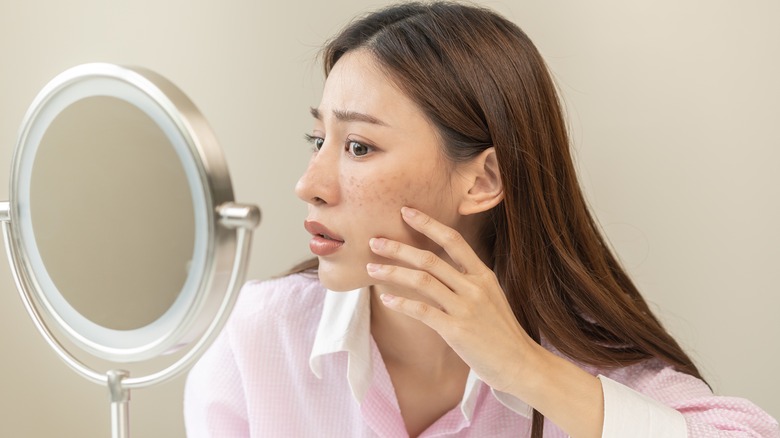 Woman dispensing retinol product from dropper