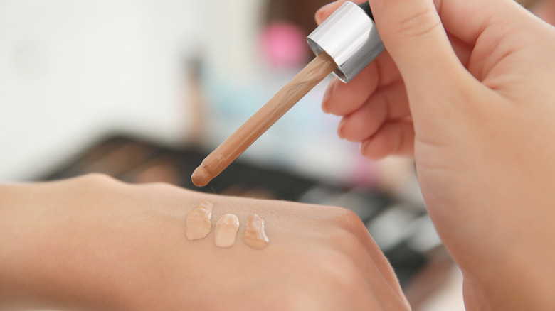 woman trying foundation shades on back of hand