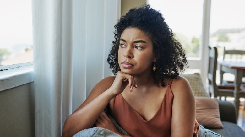 A woman looks out the window anxiously