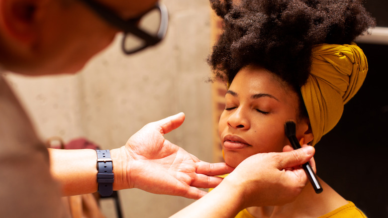 A makeup artist applying blush