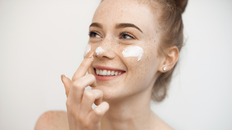 Woman applying skincare, SPF