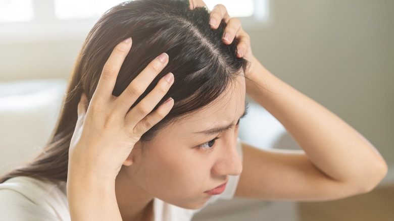 woman examining her scalp