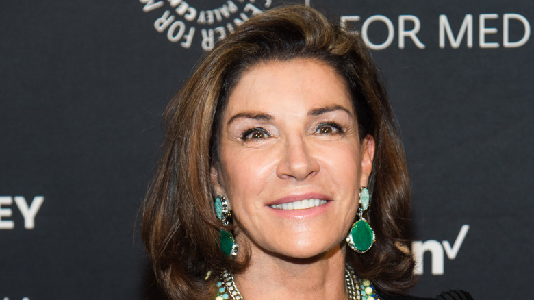 Hilary Farr smiles for a photo at an event wearing green statement accessories