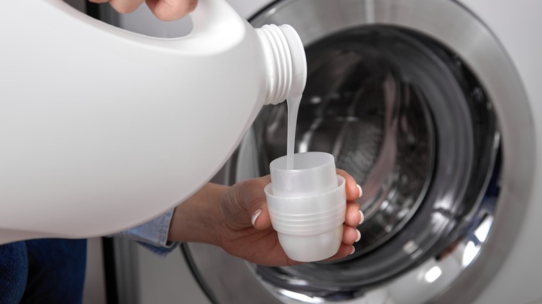 Pouring laundry detergent in to cap