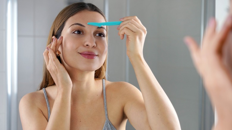 woman using dermaplaning razor