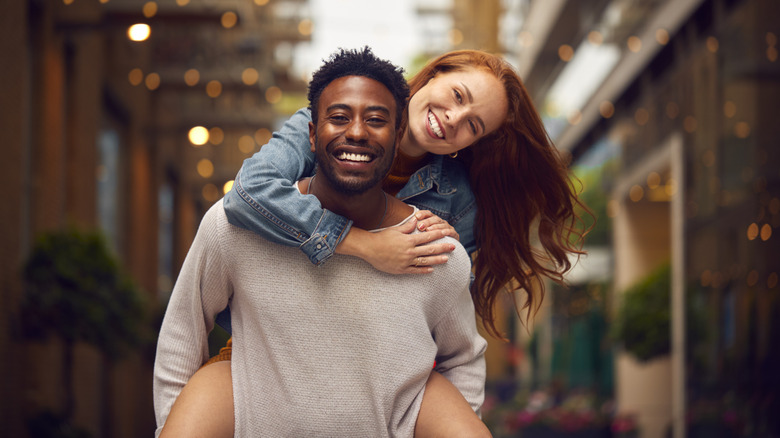 A young couple embracing, with the woman on the man's back