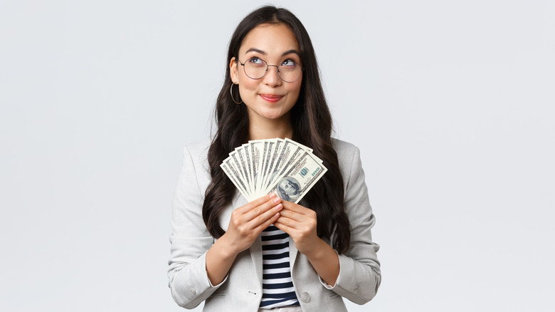 Woman holds up cash