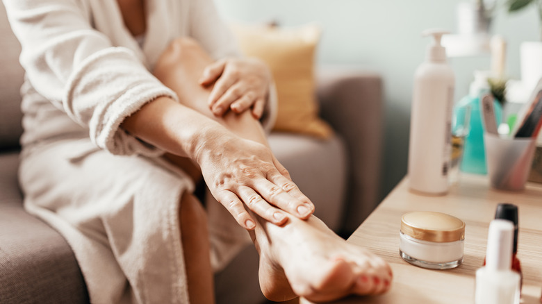 Person applying lotion to feet