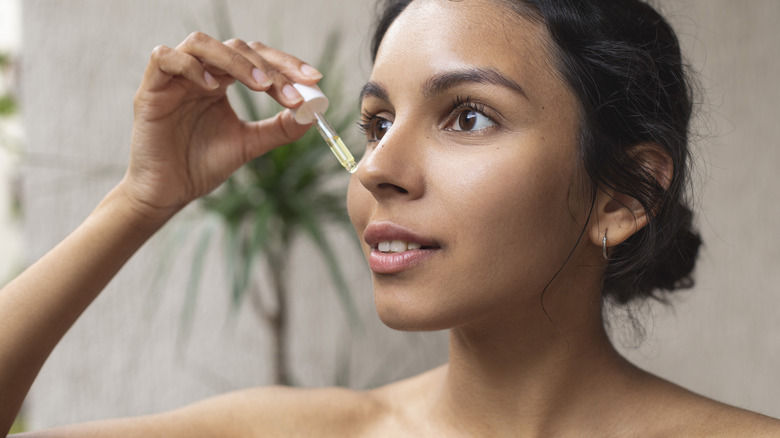 Woman applying beauty oil